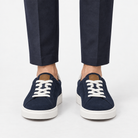 Suede sneakers with contrast heel tabs in navy, front view on a model