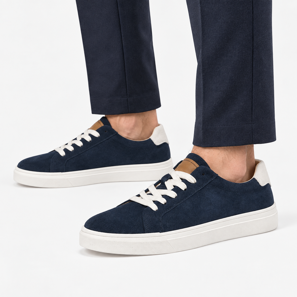 Suede sneakers with contrast heel tabs in navy, side view on a model