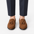 Suede tassel loafers with rubber soles in tan, front view on a model