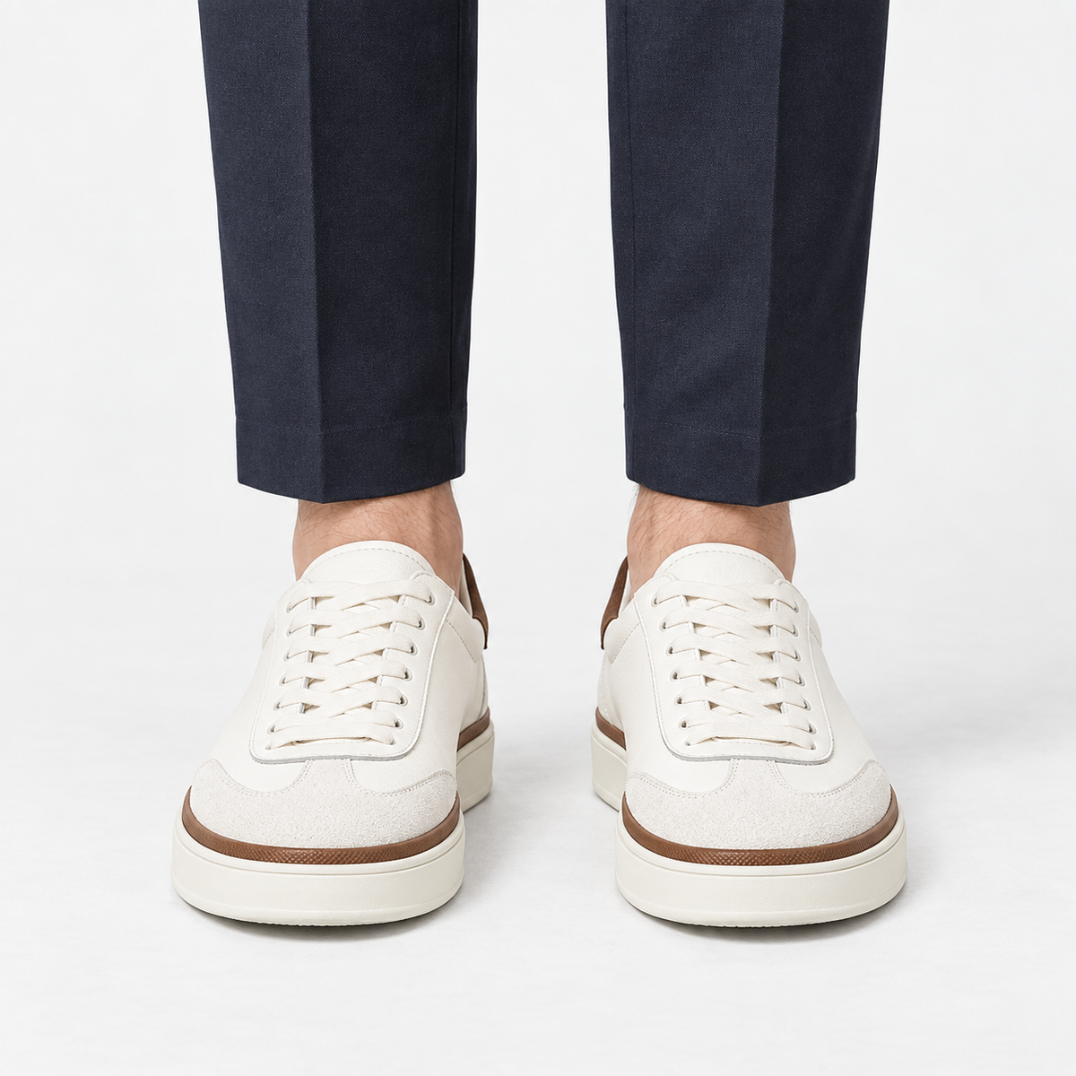 White leather sneakers with brown trim in white, front view on a model