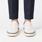 White leather sneakers with brown trim in white, front view on a model