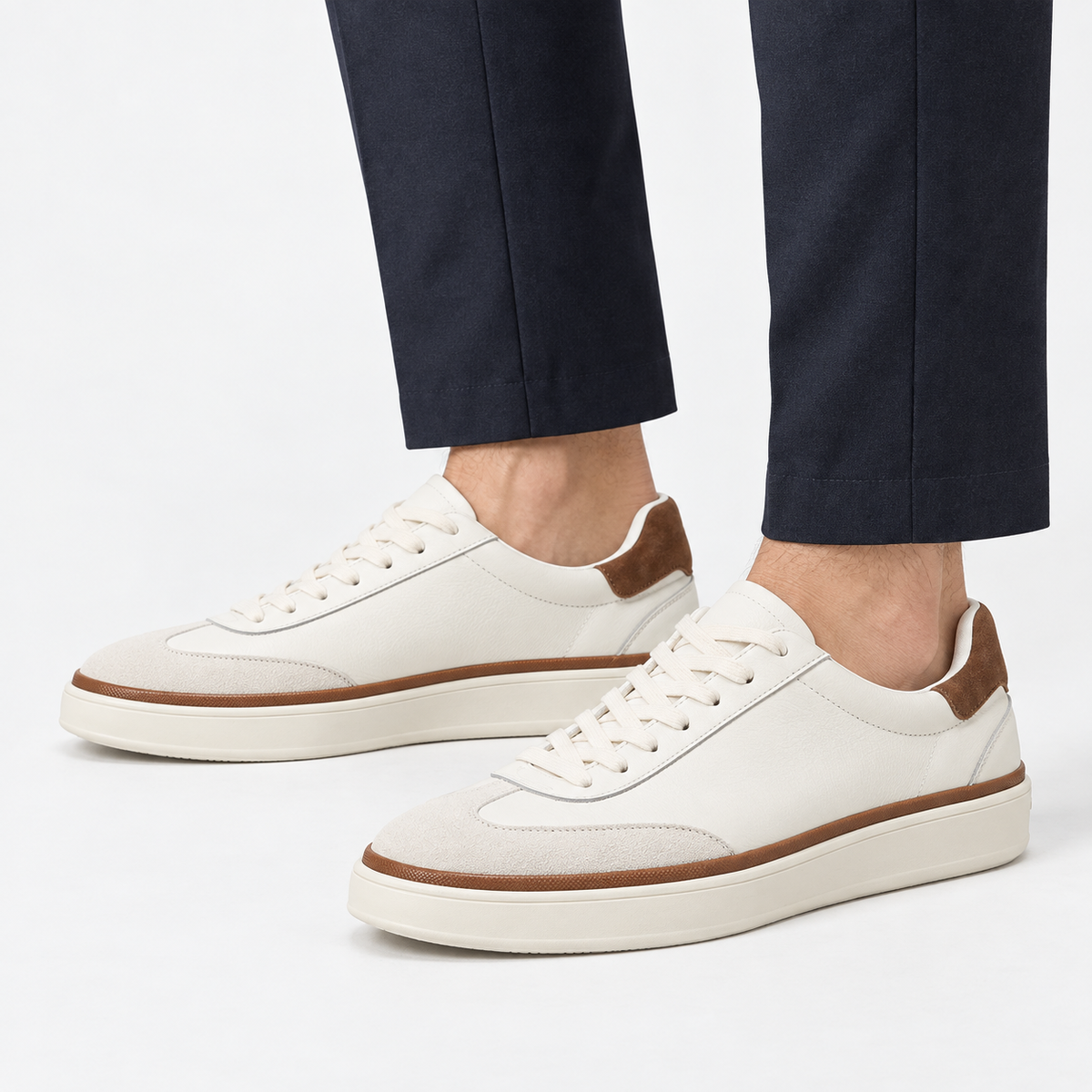 White leather sneakers with brown trim in white, side view on a model